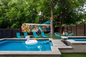 A backyard with a swimming pool, inflatable unicorn, and a colorful mural on a vehicle. - Downtown Austin Oasis Pool & Hot Tub (Austin)