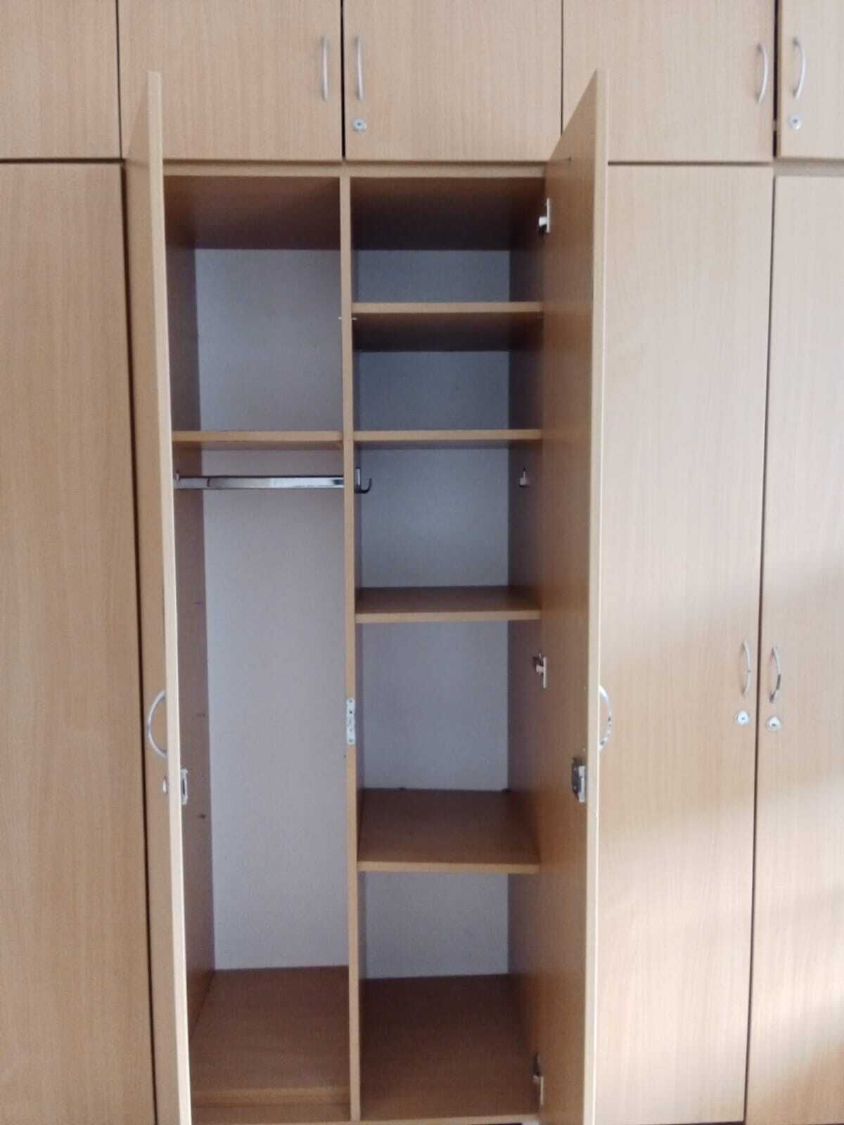 Un armario de madera con amplios estantes y espacio para colgar.
