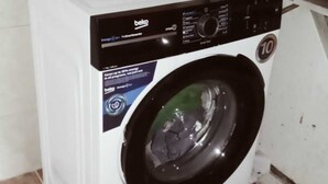 A front-loading washing machine with a control panel, a label indicating energy efficiency, and a number 10 on the door. - Ayyıldız Hostel (Belgrade)