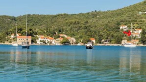 A coastal town with boats docked along the waterfront, surrounded by hills and buildings with red roofs. - Charming 2-bedroom apartment with AC, WiFi in lovely Zaton (Zaton)