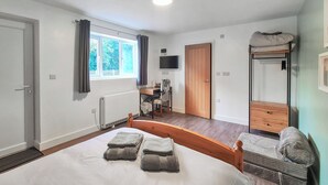 A bedroom with a bed, a desk, a TV, a wardrobe, and a bunk bed. - 1 bedroom accommodation in Walcott (Walcott)