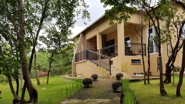 Ein zweistöckiges Haus mit einer Veranda, einer Treppe und einem Weg zum Eingang.