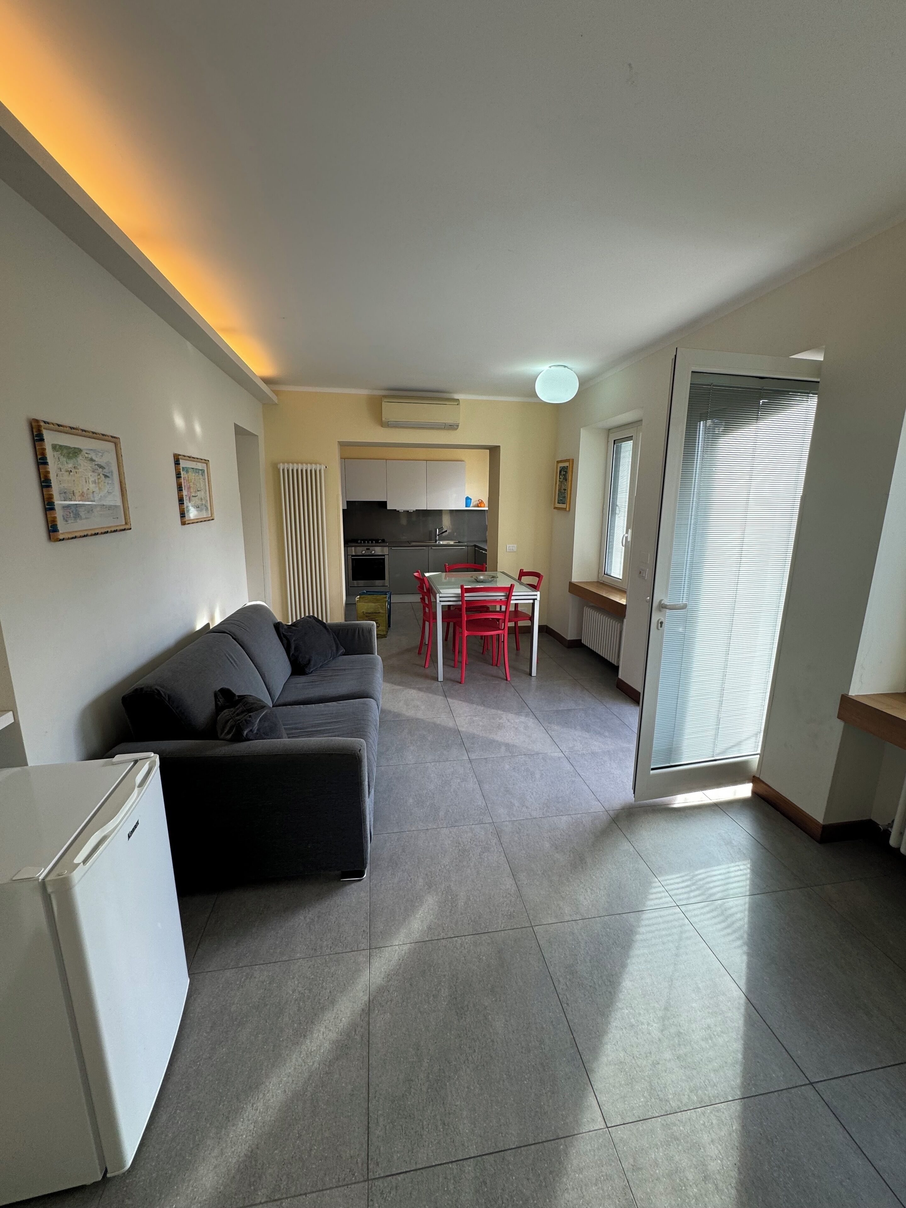 A compact living space with a kitchenette, a dining area, and a sofa.