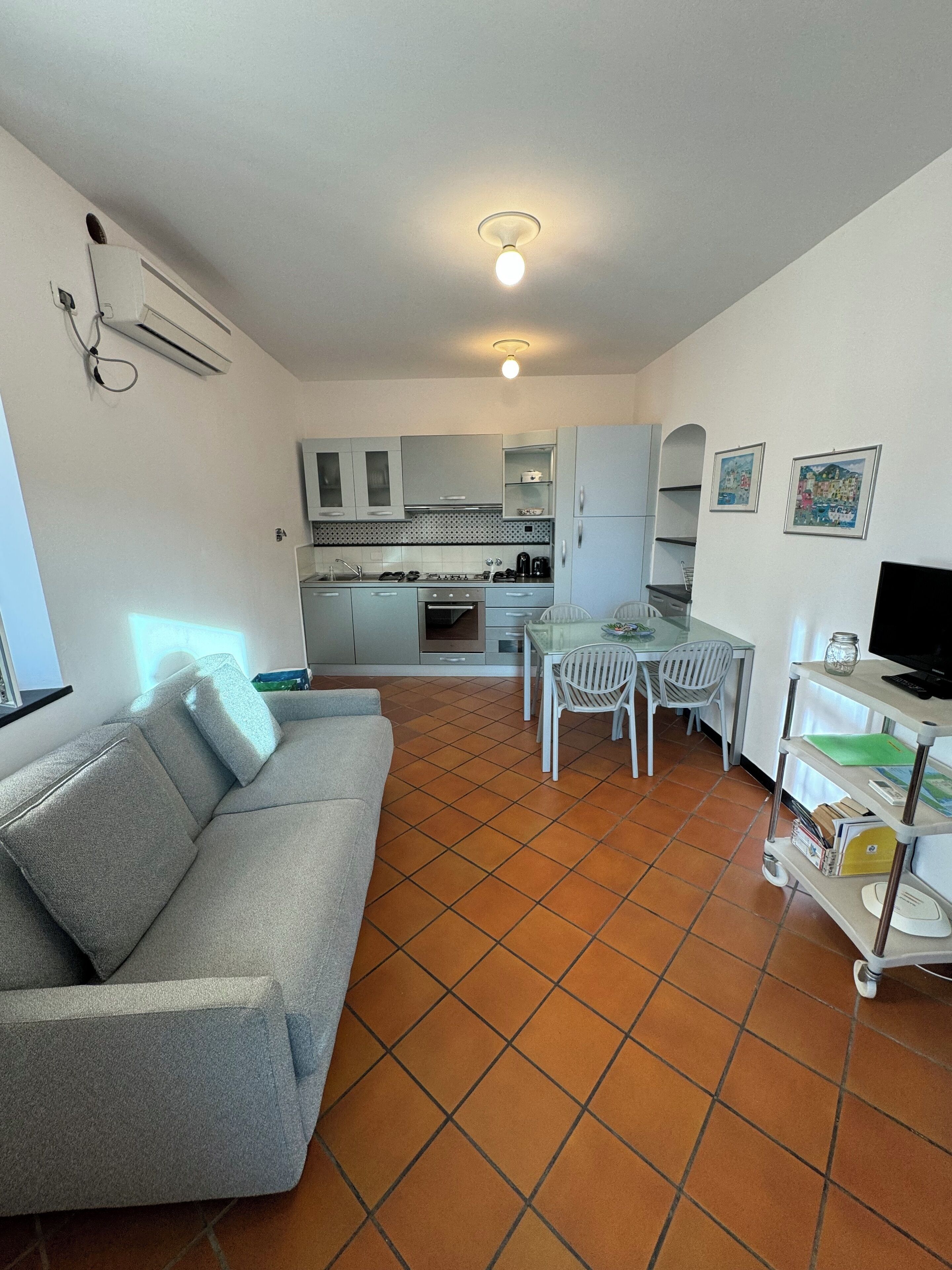 Een kleine woonruimte met kitchenette, eethoek en zithoek.
