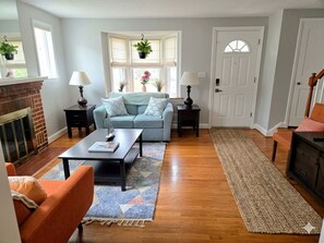 A living room with a fireplace, a sofa, a coffee table, and a door.
