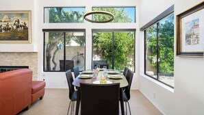 Comedor moderno con una mesa grande, sillas y vistas a zonas verdes.