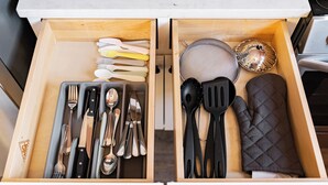 A kitchen drawer with utensils and cookware.