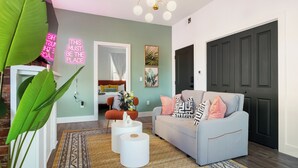 A modern living room with a grey sofa, a coffee table, and a large plant.