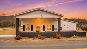 A single-story building with a gabled roof, a front porch, and a garage.