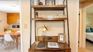 A compact workspace with a desk, chair, and shelving unit.