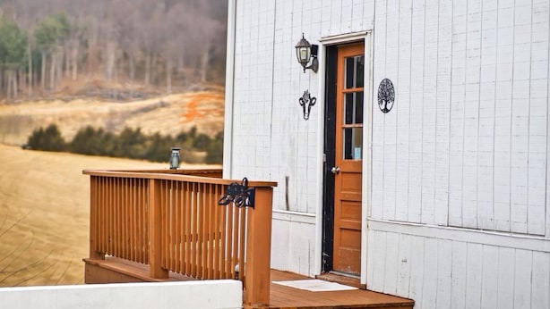 A white building with a wooden deck and a door.