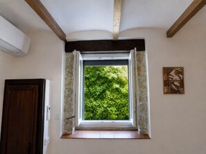 A room with a window, a door, and a wall-mounted air conditioner.