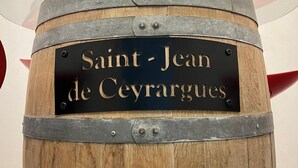 A wooden barrel with a metal band and a black label that reads "Saint-Jean de Ceyrargues".