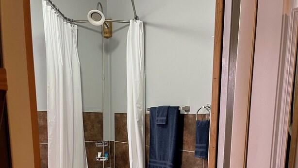 Une salle de bain avec une baignoire sur pieds, un rideau de douche et un porte-serviettes avec des serviettes.