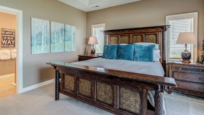 A bedroom with a large bed, wooden headboard, two bedside tables with lamps, and a ceiling fan. - Updated condo at 5100' with breathtaking views! (Sugar Mountain)