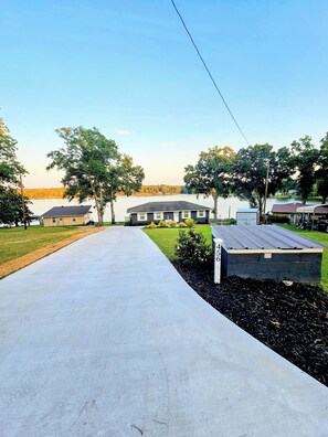 Un quartier résidentiel avec une allée pavée menant à une rangée de maisons.