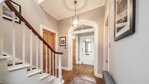 A staircase with white railings and a wooden handrail, leading to a door with a glass panel. - Blythewood Holiday Home (Kemnay)