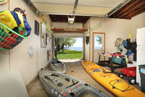 A garage with kayaks, a fishing rod, and a wall-mounted pegboard with various items.