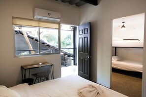 A room with a bed, a desk, and a window.