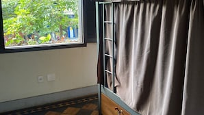 A room with a window, a bed with curtains, and a checkered floor. - Hostel Das Geraes (Belo Horizonte)