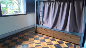 A room with a bunk bed, a window with curtains, a checkered wooden floor, and a ladder. - Hostel Das Geraes (Belo Horizonte)