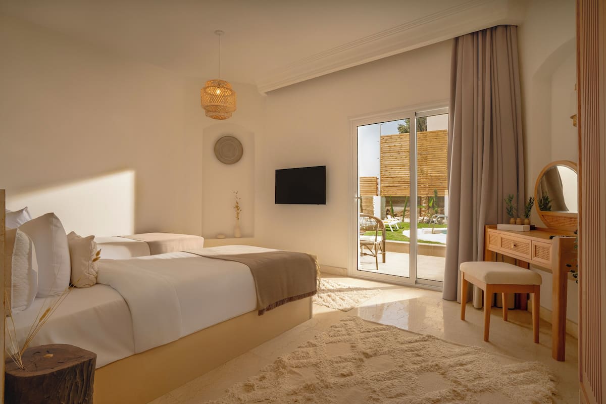 Een slaapkamer met een groot bed, een televisie, een bureau en uitzicht op de omgeving.