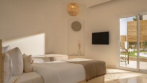 A modern bedroom with a large bed, a bedside table, a wall-mounted TV, and a view of the outdoors through a sliding glass door. - Noya By Dhara Hotels (Giza)