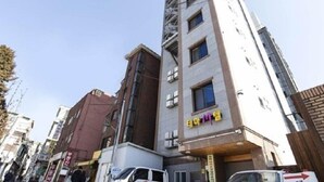 A multi-story building with a sign in Korean. - Thema Motel (Seoul)