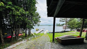 Un espace extérieur abrité avec un chemin pavé menant à un quai au bord d’un lac.