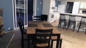 Una cocina pequeña con armarios blancos, un microondas y un lavamanos.