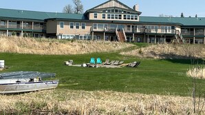 A large building with multiple balconies and a grassy area in front.
