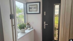 Una habitación con ventana, puerta y vistas al exterior.