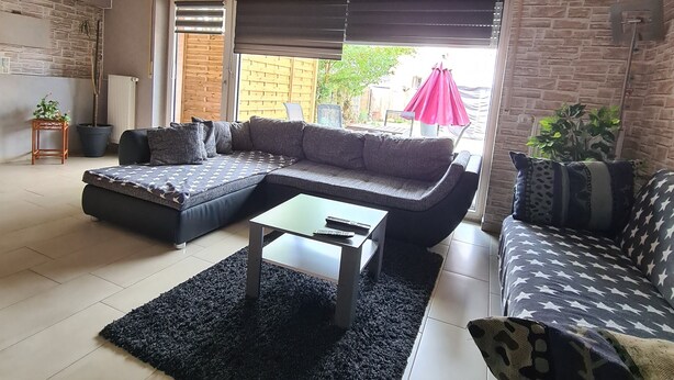 Una sala de estar moderna con un sofá, una mesa de centro y una alfombra.