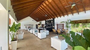 A spacious indoor area with high ceilings, wooden beams, and a bar area with seating. - APARTAMENTO VISTA MARE 14-101 (Samana)