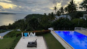 A swimming pool with a view of the sea, a lounge area with chairs and a table, and a sign with 'I ❤️ VM'. - APARTAMENTO VISTA MARE 14-101 (Samana)