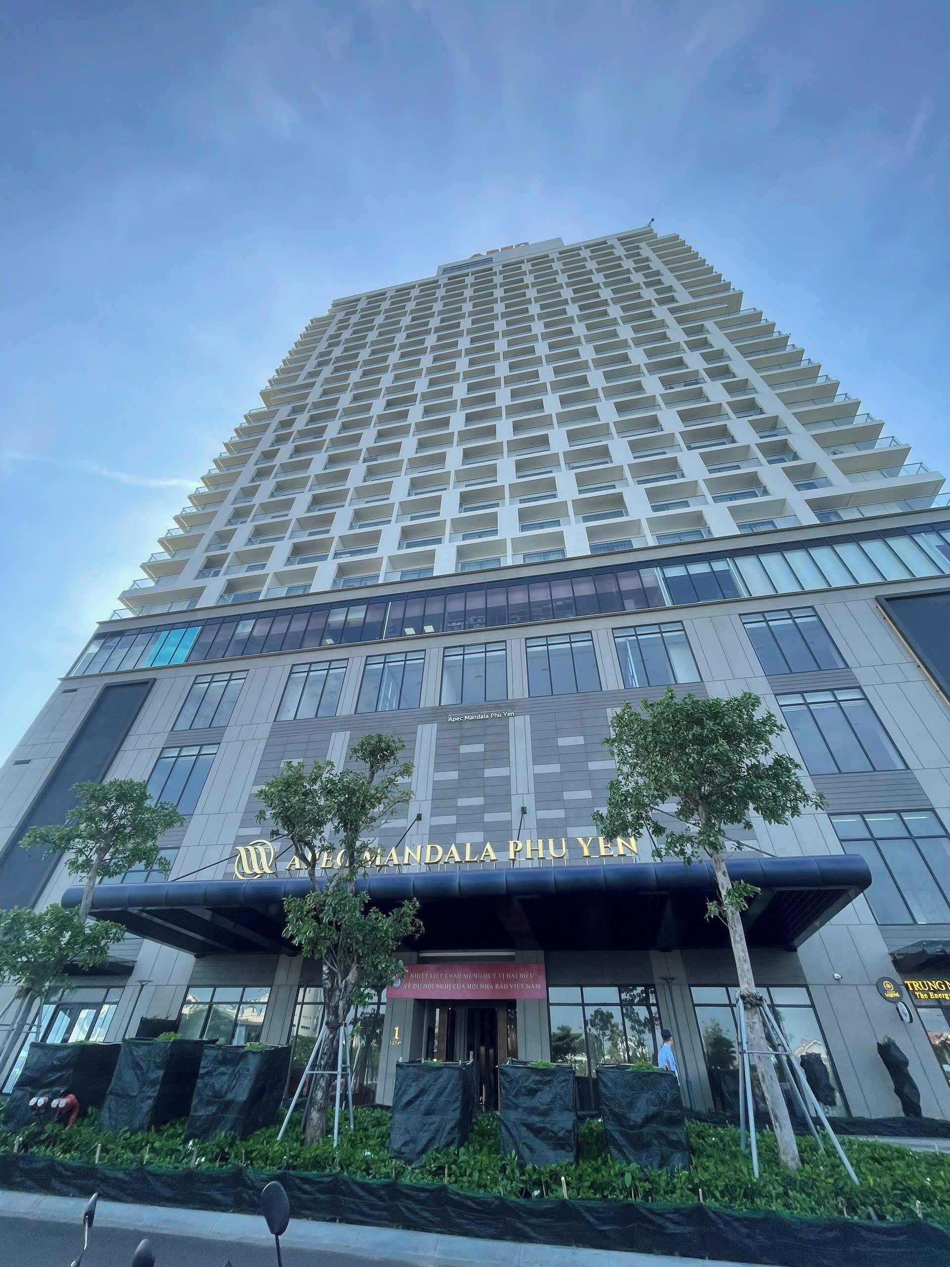 A tall, modern building with a prominent sign reading "APEC Mandala Phu Yen".