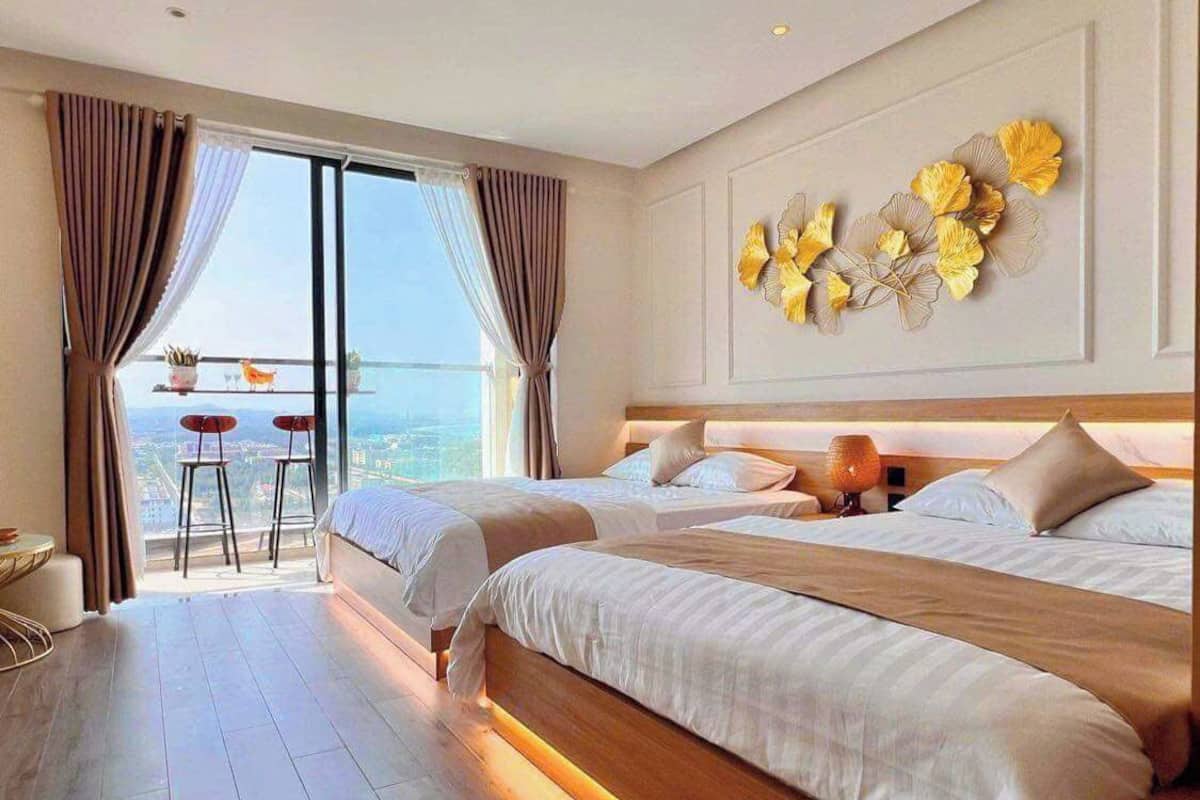 Ein Hotelzimmer mit zwei Betten, einem Balkon und Blick auf die Stadt.