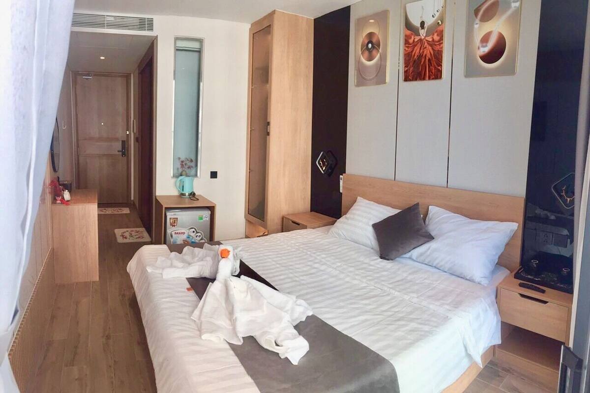 Ein Hotelzimmer mit einem großen Bett, Nachttischen, einem Spiegel und einem Kleiderschrank.