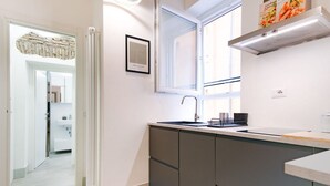 A modern kitchen with a window, a sink, and a built-in oven. - Elegantis.it Trastevere Modern Apartment Comfort in Rome Most Charming District (Roma)