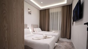 A hotel room with two beds, a flat-screen TV, and a large window with curtains. - Living Appart Hotel (Tangier)