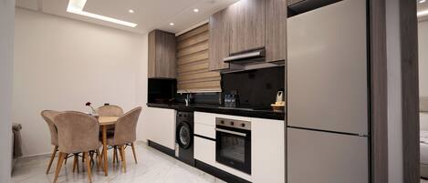 A modern kitchen with a dining area, built-in appliances, and a clean, minimalist design.