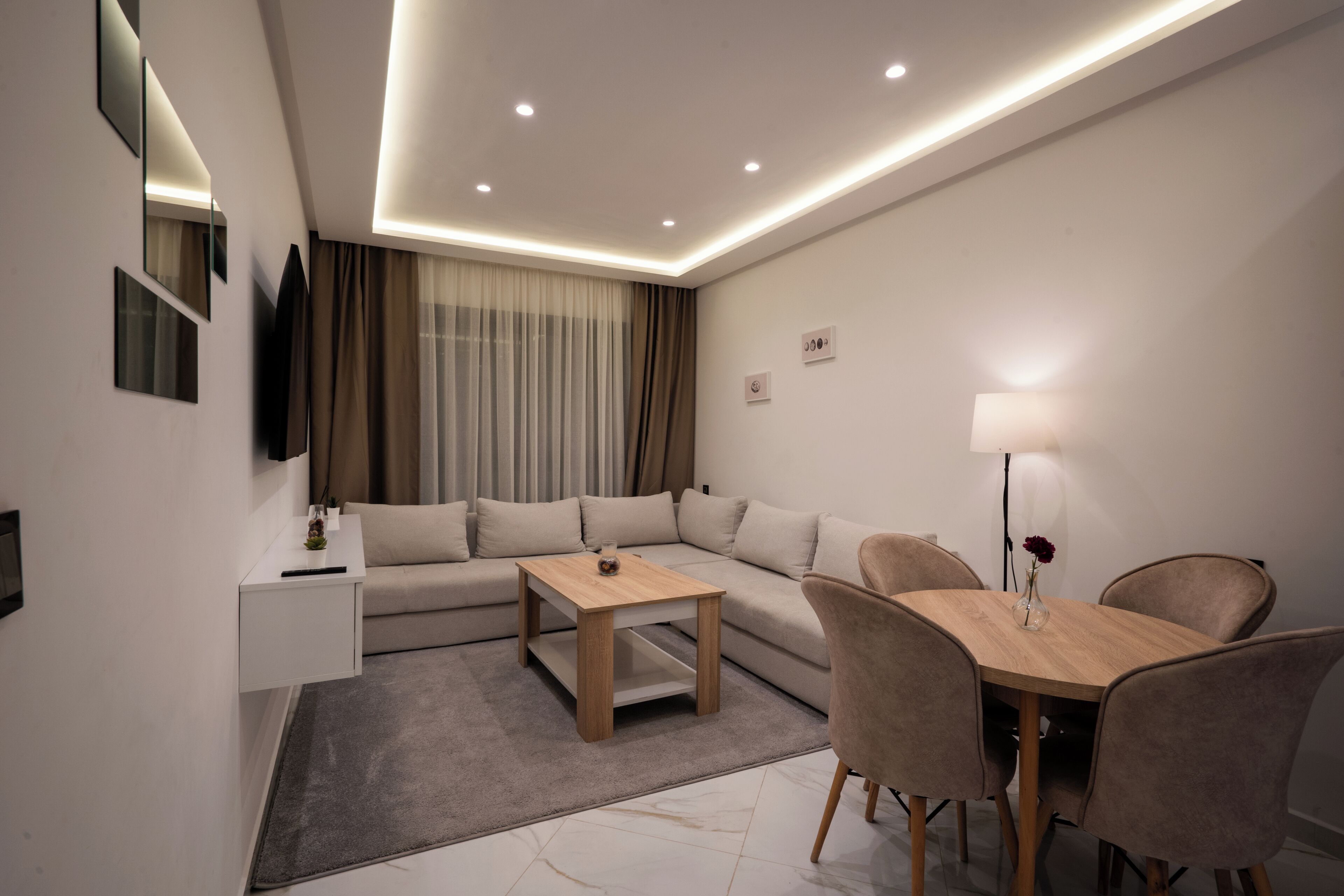 Un salon moderne comprenant un canapé, une table basse et une table à manger avec des chaises.