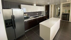 Eine moderne Küche mit Kühlschrank, Mikrowelle, Backofen und Spüle.