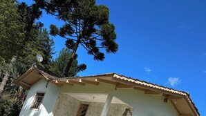 Ein eingeschossiges Haus mit Ziegeldach, einer kleinen Veranda und einem Fenster mit Fensterläden.