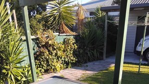 A glass-top table with wicker chairs on a wooden deck. - Charming 3-bedroom house walking distance to the wonderful Napier, marine parade (Napier)