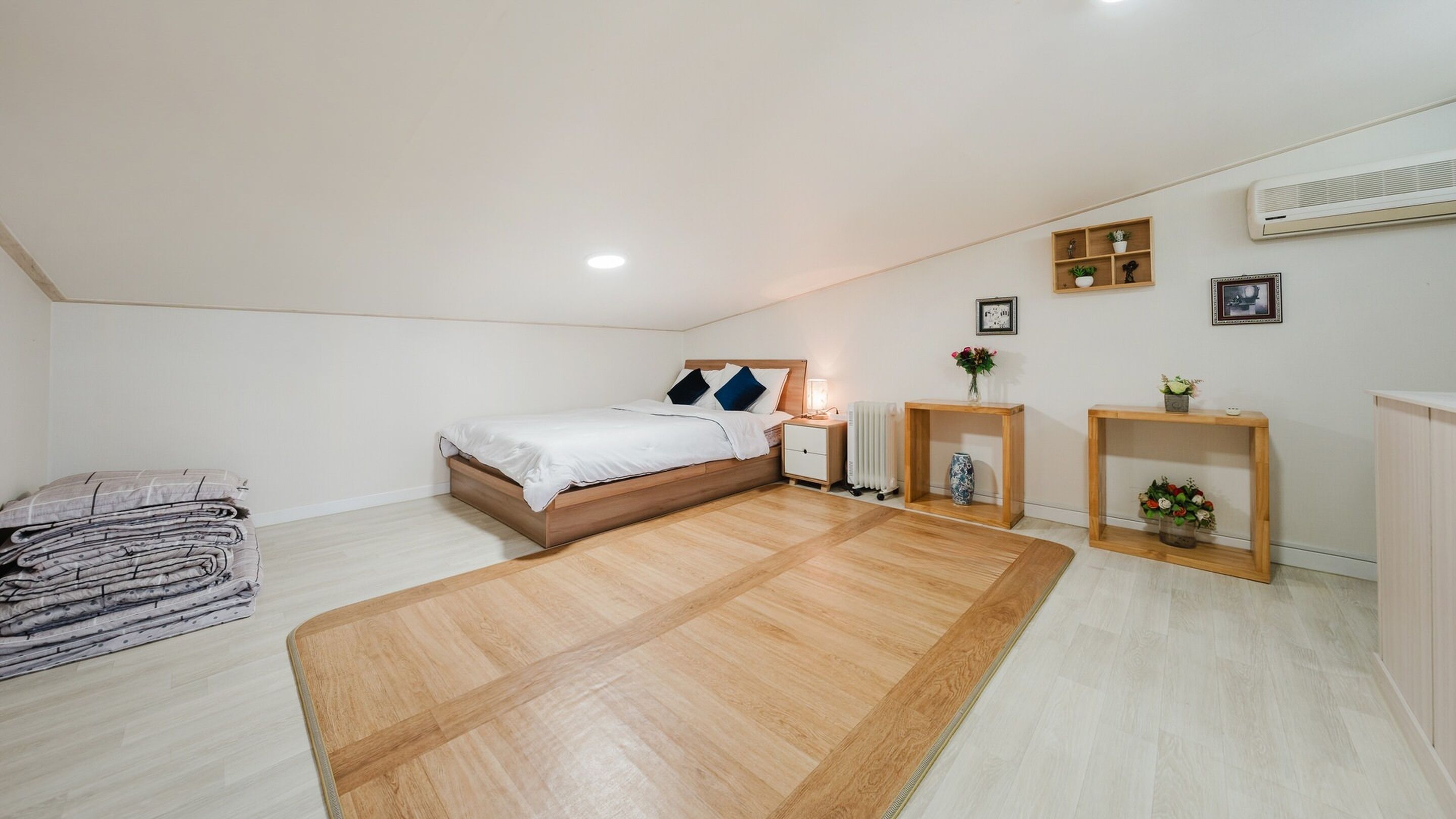 A bedroom with a wooden bed, bedside tables, a radiator, and a small wooden shelf with a vase.