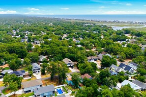 Zona residencial con casas rodeadas de árboles y vista al océano.
