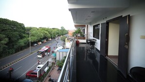 A balcony with a view of a busy street and greenery. - Hotel Park Gardenia (Nagpur)