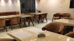 A conference room with a long table, several chairs, and a glass partition. - Hotel Park Gardenia (Nagpur)