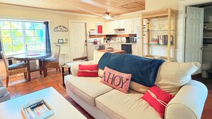 Un salon chaleureux avec un canapé beige, une table basse blanche et un ventilateur de plafond.